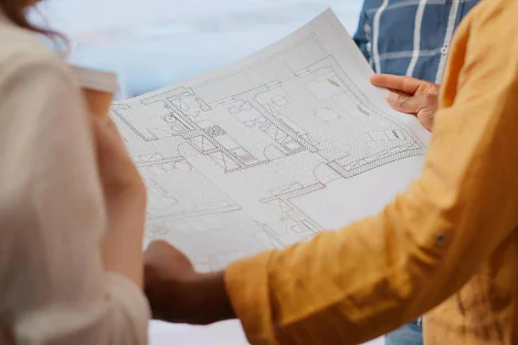 Planos arquitectónicos sobre una mesa de trabajo.